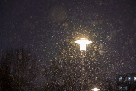 Lantern at night in heavy snowfall, snow against aの写真素材