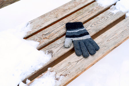gloves on a wooden bench on a cold winter dayの写真素材