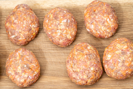 raw homemade meatballs on a massive board made ofの写真素材