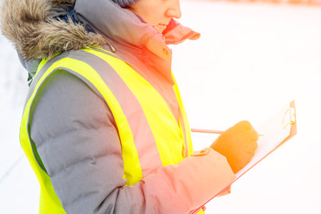 construction engineer writes close-up notes in