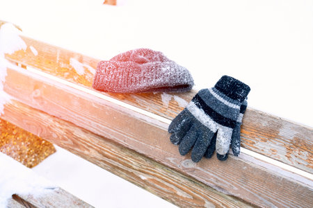 gloves on a wooden bench on a cold winter dayの写真素材