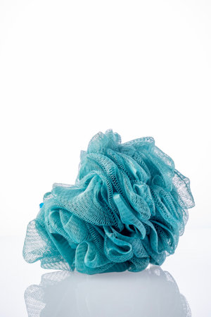 New washcloth on a white . New shower puffs on white background High quality photo