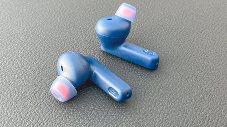 Moscow, April 07 2024, Two blue earbuds with pink tips on a black surface. The earbuds are placed...