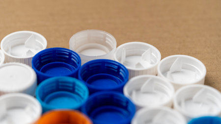 A row of plastic caps with blue and white colors. The caps are arranged in a way that they look like a puzzleの写真素材