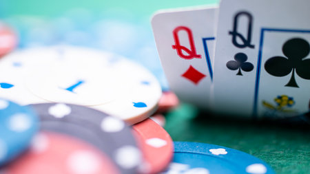 Queen of Diamonds and Queen of clubs playing cards on a poker table in close-up. A poker player...
