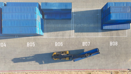 The forklift operator hoisted the cargo container in the shipping yard for transportation. The...