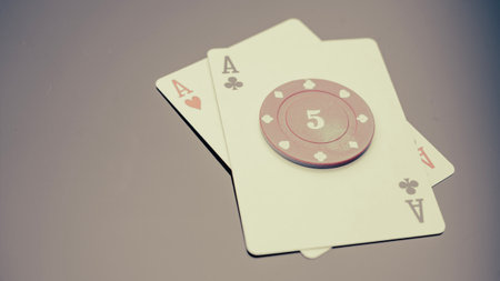 A card game chip with two aces, black background with a gradient. Cards on a black table is a...