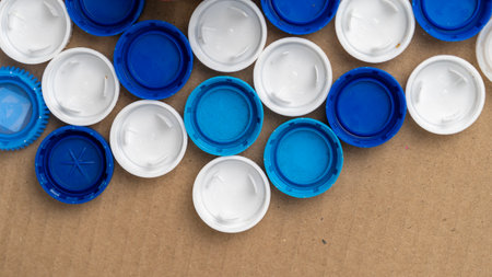 A collection of blue and white plastic caps, with the blue caps on top of the white onesの写真素材