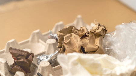 A cardboard box with a piece of paper on top of it. The paper is crumpled and torn
