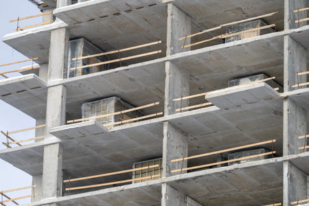A tall building with scaffolding and wooden poles. The building is under construction