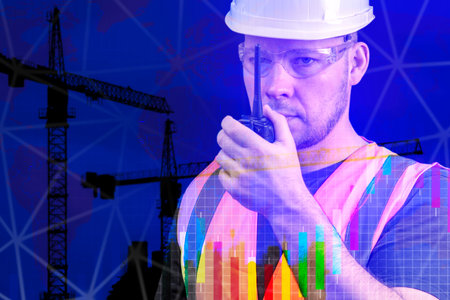 Construction worker communication. A civil engineer in a white helmet and orange vest talks on a...