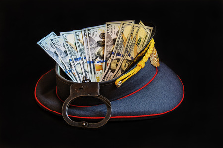 Abstract picture with the image of a police cap, handcuffs and US currencyの写真素材