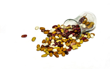 On the white surface are scattered from the glass beaker bean beans
