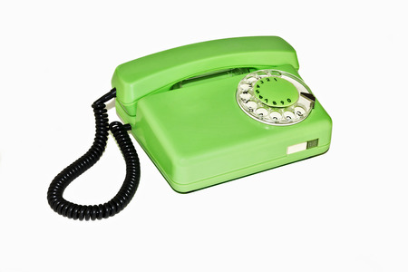 On a white background is an old telephone with a rotary dialerの写真素材