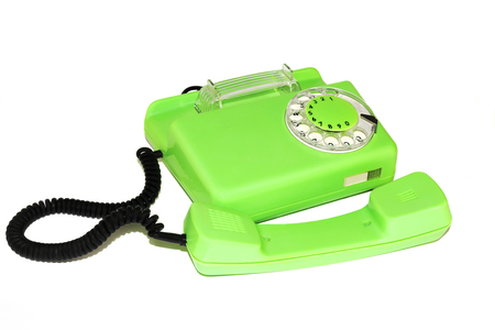 On a white background is an old telephone with a round dialerの写真素材