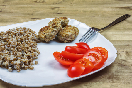 Buckwheat porridge with meat cutlets and red tomatoesの写真素材
