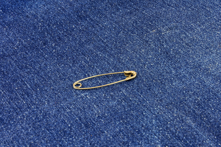 Metal buttoned pin lies on blue jeans materialの写真素材