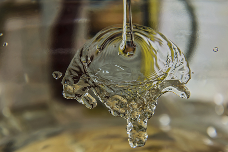 A stream of water splits about a transparent surface and flows downの写真素材