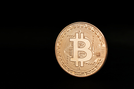 Golden Bitcoin coin on the black background, place for inscriptionの写真素材
