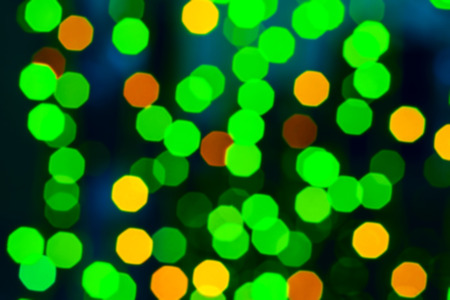 Colorful bokeh. Creative image of bright festive lights in green and orange tones, blurred...
