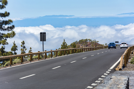 Spain, Tenerife-may 10, 2018: mountain landscape with thick clouds. Two cars on a mountain road and dense clouds on the mountainside.のeditorial素材