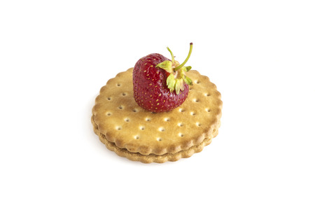 On a two-layer cookie close-up is a strawberry berry, white backgroundの写真素材