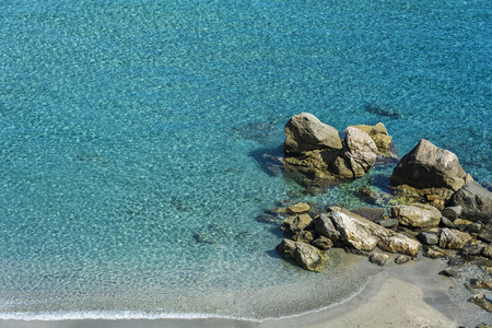 Clear  and clean turquoise water on the beach with small stonesの写真素材