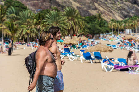Spain, Tenerife - September 12, 2016 Two men go to the beach to swim and sunbatheのeditorial素材