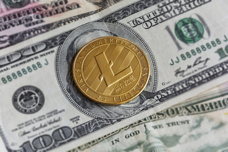 The gold coin LITECOIN rests on cash, close-upsの写真素材
