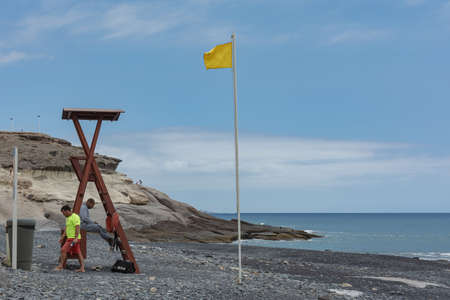 Tenerife, Spain - 05/110/2018: Lifeguards on a deserted beach and a yellow flag. Stock photoのeditorial素材