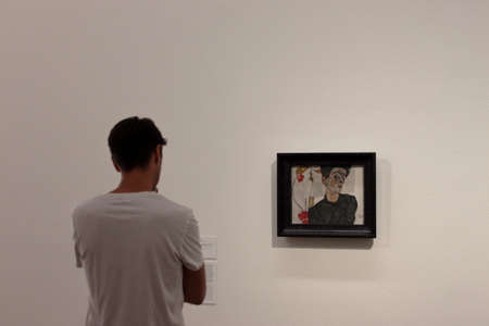 Man with white tshirt looking at Egon Schiele self portrait at Leopold Museum, Wienのeditorial素材
