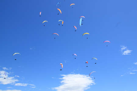 a group of paratroopers fly paragliding over the Italian Alpsの写真素材