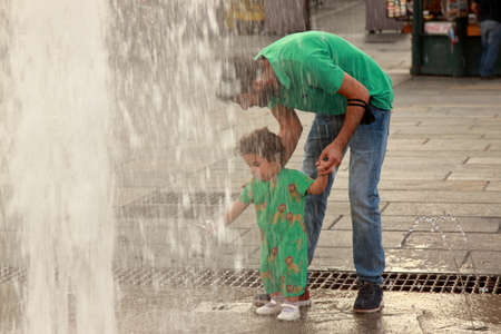 Turin - september 2020: a father makes his daughter play in a city fountain near royal palaceのeditorial素材