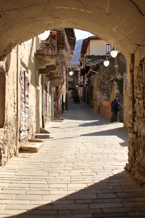 mother and son walk along the streets of a small village in the Italian Alps
