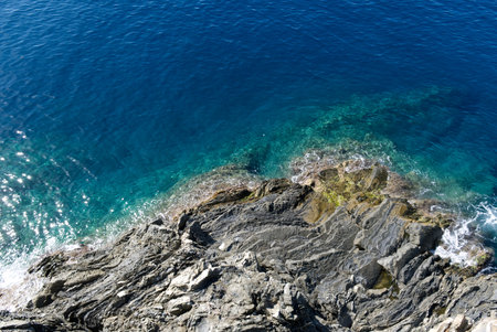 Top view of a turquoise sea and black granite cliffの写真素材