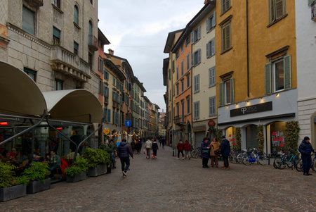 View of typical narrow cobbled street of historical Italian city of Bergamo with colorful buildingsのeditorial素材