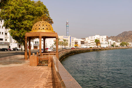 Golden ornated dome gazebo in traditional Omani style with port and cruise ships in the background,の写真素材