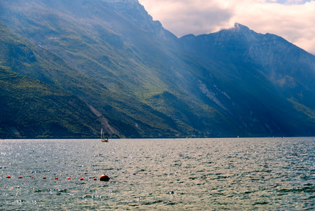 Sailing boats on Garda Lake, beautiful Lake Garda surrounded by mountainsの写真素材