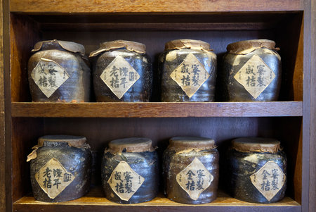 traditional chinese ceramic jars for medicine on wooden shelfの写真素材