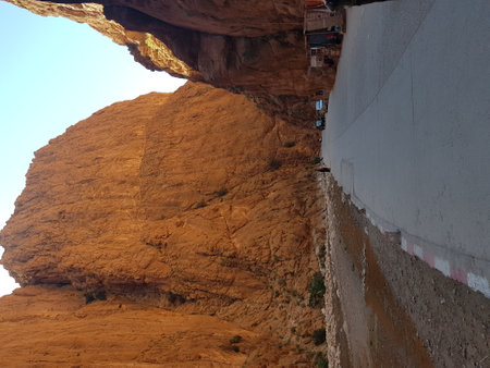 A person stands in front of a significant large rock formationの写真素材
