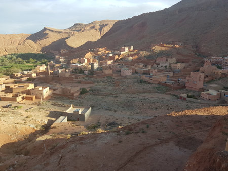 A small town in a vast desert, surrounded by beautiful mountainsの写真素材