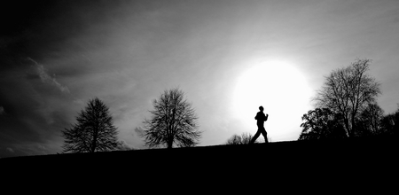 Silhoette of a runner on a horizon in winterの写真素材