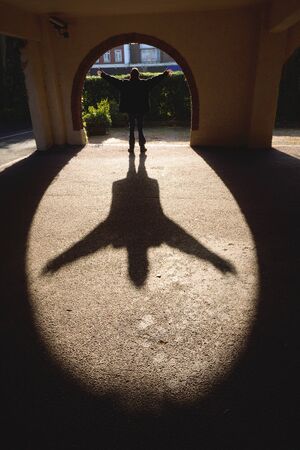 Shadow of a man spreading hand towards sun