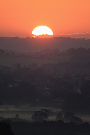 Sunrise on a misty morning over Axe Valley in East Devon, Englandの写真素材