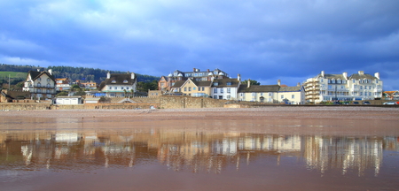 Wet sandy beach during low tide in Sidmouth, Devon