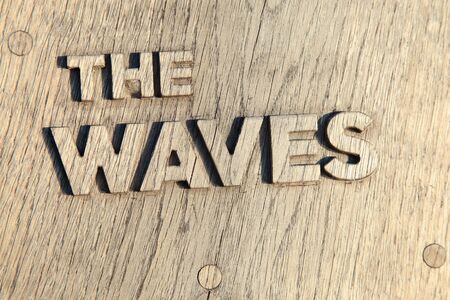 The waves text engraved on wooden boardの写真素材