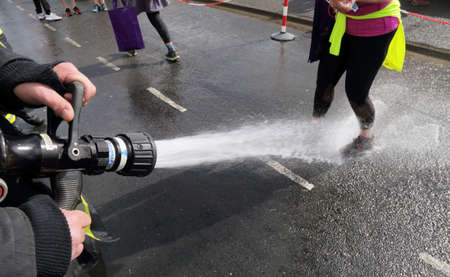 SEATON, UK-MARCH 8, 2020: Washing shoes with water hose after finishing multi terrain 20 mile The...