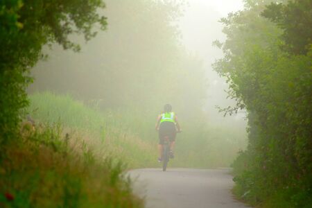 Bicyclist on the foggy morning in Seaton Wetlands, Devon