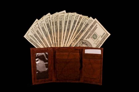 New wallet with no credit cards and lots of cash isolated on blackの写真素材
