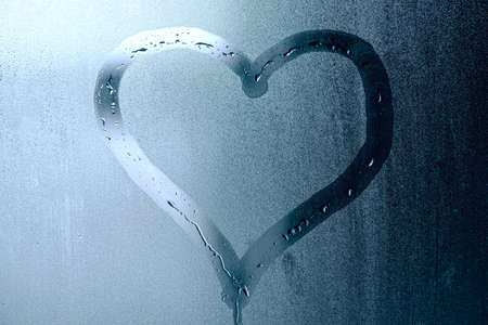 Shape of heart on window with steam and condensation after rain, concept pictureの写真素材